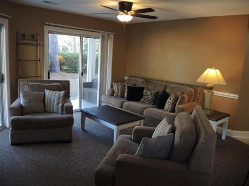 una sala de estar con sofás y sillas y un ventilador de techo. en Lake View Golf Resort Villa 1301, en Calabash