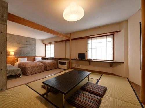a large room with two beds and a table at the Kinta Naeba in Yuzawa