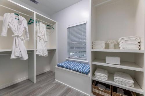 a walk in closet with white towels and a window at 5/3 with a heated pool 2 min from beach, updated in Galveston