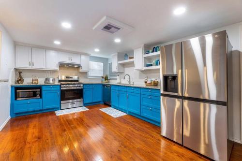 a kitchen with blue cabinets and a stainless steel refrigerator at 5/3 with a heated pool 2 min from beach, updated in Galveston