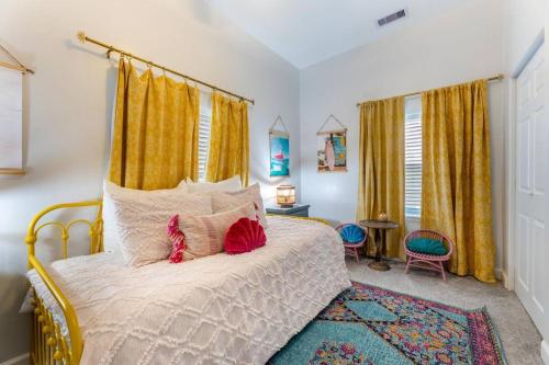a bedroom with a bed with yellow curtains at 5/3 with a heated pool 2 min from beach, updated in Galveston