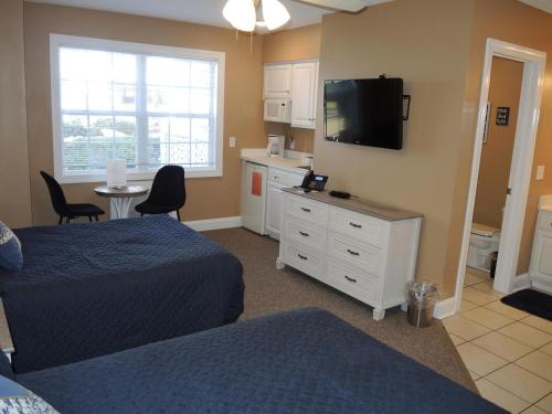 a hotel room with two beds and a flat screen tv at Brunswick Plantation Studio Home 1301L in Calabash