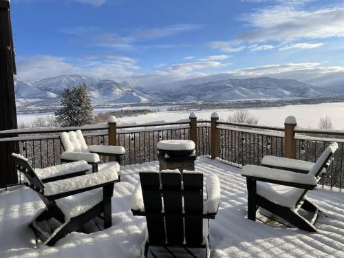 a snow covered porch with two chairs and a fence at Snowbasin + Powder Mountain + Spa + Eden in Eden