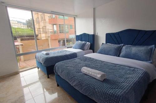 Apartamento Nuevo y Central في Santa Rosa de Viterbo: غرفة نوم بسريرين ونافذة كبيرة