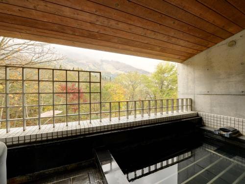 a room with a large window and a pool of water at the Kinta Naeba in Yuzawa