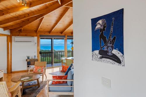 a living room and dining room with a guitar on the wall at Peace & Plenty in Swansea