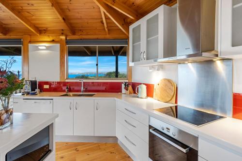 a kitchen with white cabinets and a wooden ceiling at Peace & Plenty in Swansea