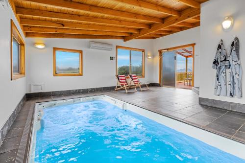 a swimming pool in a house with a wooden ceiling at Peace & Plenty in Swansea