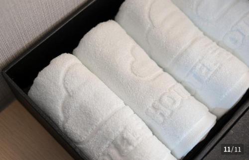two white towels in a box on a table at Ggumgguda Hotel in Anyang