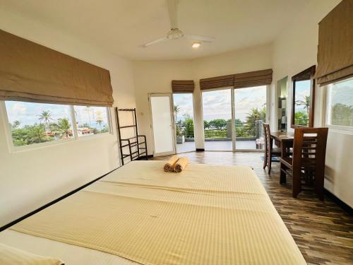 een slaapkamer met twee bedden en een tafel en stoelen bij Little Paradise in Weligama