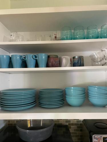 a shelf filled with blue bowls and plates at Sunny Oasis Getaway -Heated Pool-Mini Golf-Near Beach in Nokomis