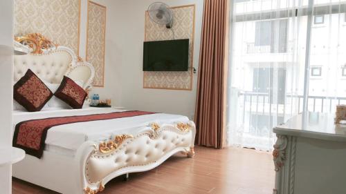 a bedroom with a white bed and a large window at LAS VEGAS HOTEL in Quang Ninh