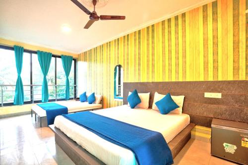 um quarto com 2 camas e almofadas azuis em Swastic Hotel at Calangute GOA em Calangute