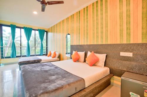 a bedroom with two beds and two windows at Swastic Hotel at Calangute GOA in Calangute