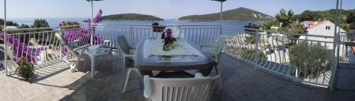 a table and chairs on a balcony overlooking the water at "Azzurra Apartments in Molunat