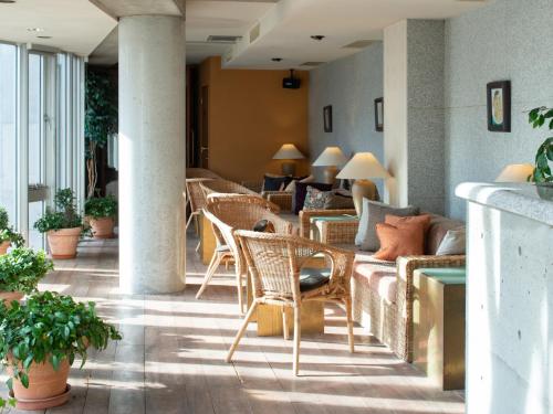 a lobby with wicker chairs and couches and tables at the Kinta Naeba in Yuzawa