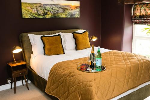 ein Schlafzimmer mit einem Bett und einem Tablett mit Getränken darauf in der Unterkunft Candle House By Muse Escapes in Castleton