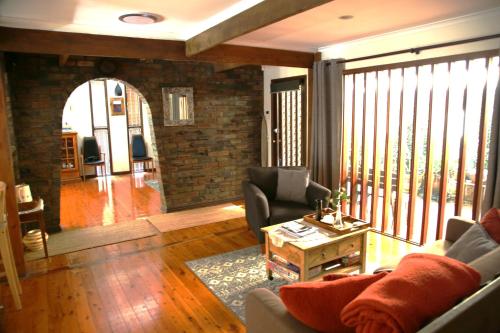 a living room with a couch and a table at A Holiday Home for Every Season in Bateau Bay