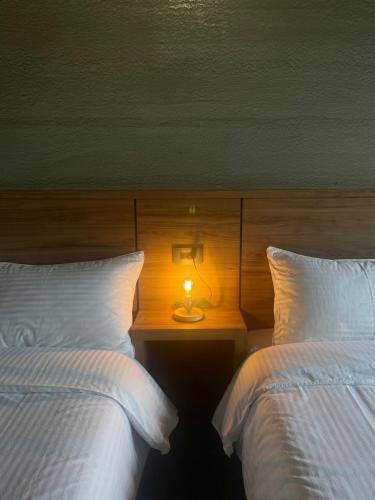 two beds in a hotel room with a lamp on a table at 沐目家 Xiang Jia Homestay in Beipu