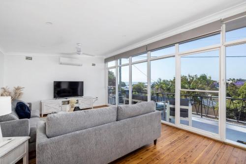 a living room with a couch and a television at Coastal Cottage in Nelson Bay - Pet Friendly in Nelson Bay