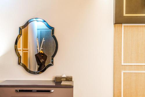 a mirror on a wall above a dresser at Gongju No 25 Hotel in Gongju