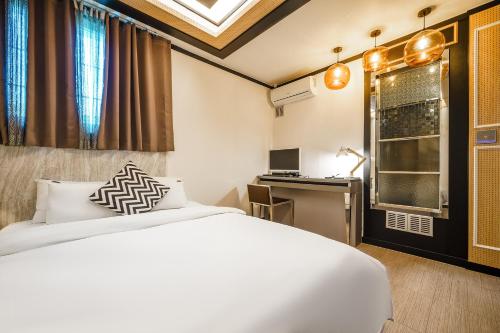 um quarto de hotel com uma cama e uma secretária em Gongju No 25 Hotel em Gongju