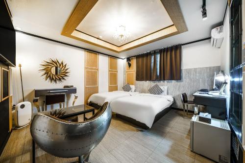 um quarto de hotel com uma cama e uma secretária em Gongju No 25 Hotel em Gongju