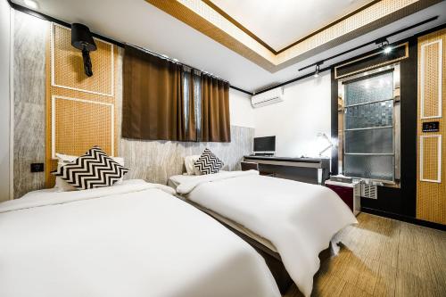 a bedroom with two beds and a desk and a window at Gongju No 25 Hotel in Gongju