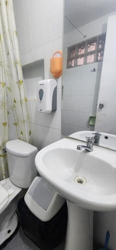 a bathroom with a white sink and a toilet at Departamento amoblado in Pucallpa