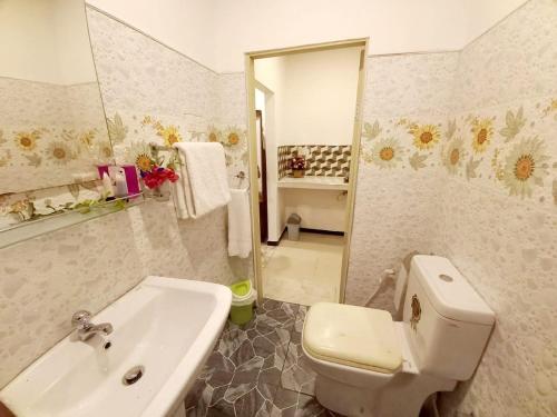 a bathroom with a white toilet and a sink at Dinu Lanka Resort in Katunayaka