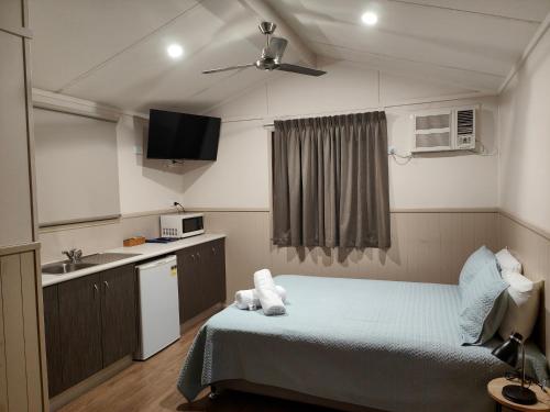 a small room with a bed and a sink at Carmila Caravan Park & Cabins in Carmila