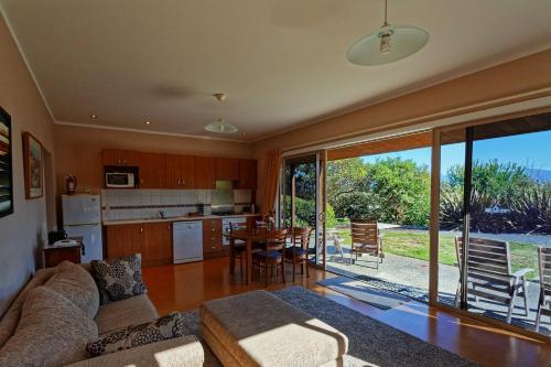 uma sala de estar com um sofá e uma cozinha com uma mesa em Clayridge Cottages em Upper Moutere