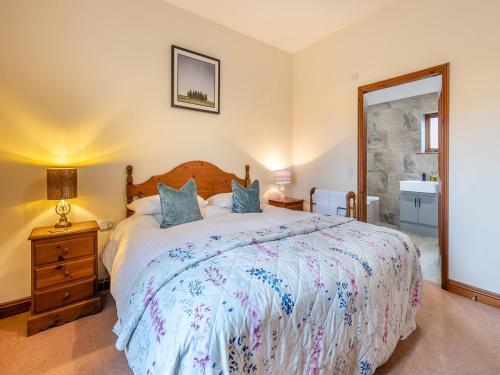 a bedroom with a large bed and a mirror at Ash Cottage - Uk45581 in Maltby le Marsh