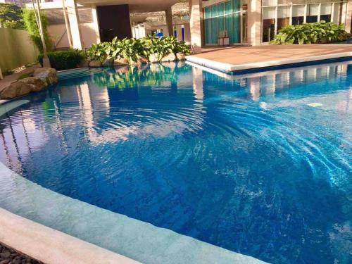 a large swimming pool in a building with blue water at Kasara Condo Staycation by Vhi in Manila