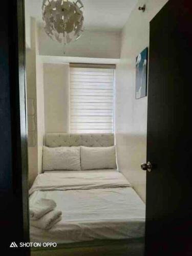 a small room with a bed in a window at Kasara Condo Staycation by Vhi in Manila