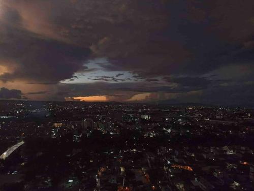 a city skyline at night with a cloudy sky at Kasara Condo Staycation by Vhi in Manila