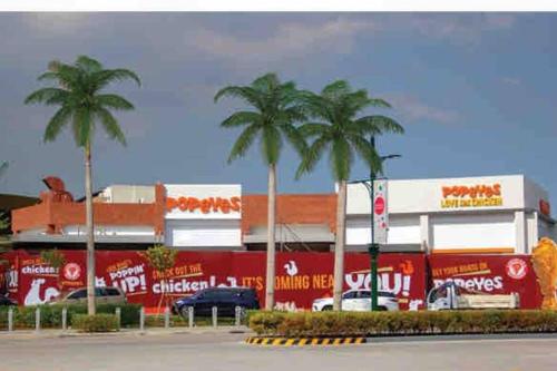 a parking lot with palm trees in front of a building at Kasara Condo Staycation by Vhi in Manila