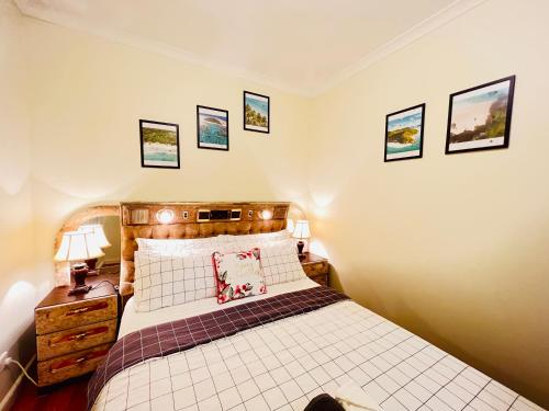 a bedroom with a bed and some pictures on the wall at Cosy Homes - 15 Minutes Away From Melbourne Airport in St Albans