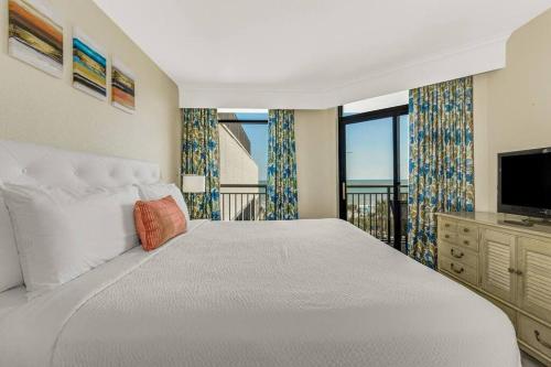 a bedroom with a large bed and a television at Breathtaking Oceanfront 3BR,2BA Suite/Grand Cayman 451 in Myrtle Beach