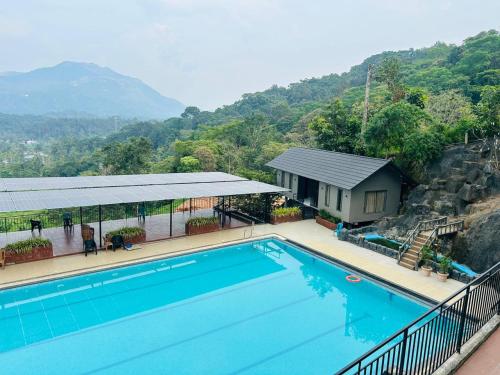a view of a swimming pool with a house at Konfudha Resort in Kalpetta