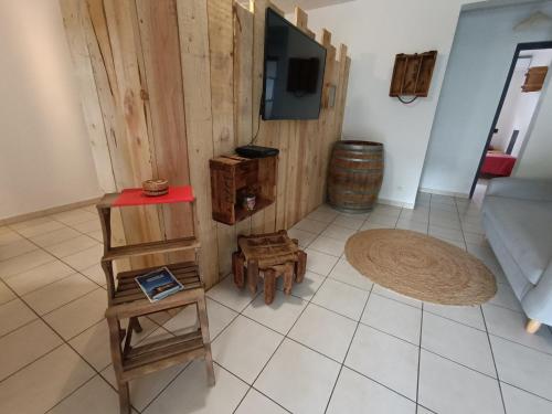 a living room with wooden furniture and a flat screen tv at Villa Korail Caraibes in Les Trois-Îlets