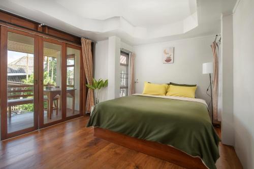 een slaapkamer met een bed en een balkon bij Betel Palm Village - Casa Retreat in Pai