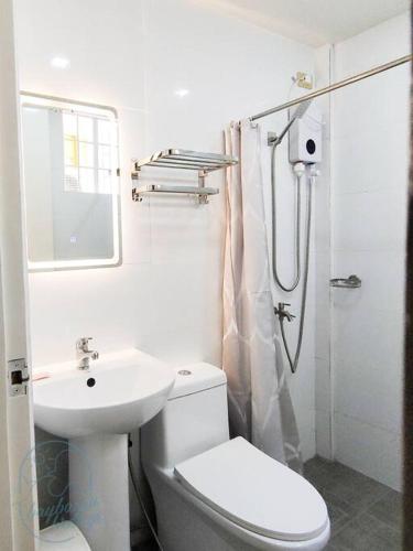 a white bathroom with a toilet and a sink at Private Guest House Bay Breeze in San Juan