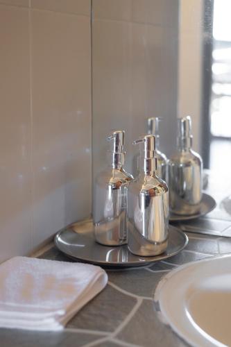 a bathroom counter with four bottles on a tray at Betel Palm Village - Casa Retreat - WiFi 90 Mbps in Pai