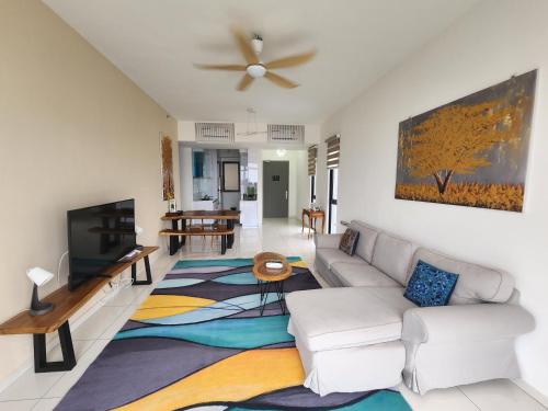a living room with a couch and a flat screen tv at Beacon Executive Suites in George Town