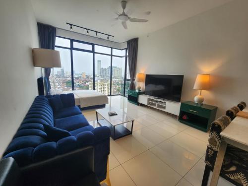 a living room with a blue couch and a television at Beacon Executive Suites in George Town