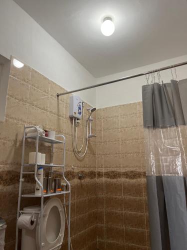 een badkamer met een douche, een toilet en een douchegordijn bij The Coffee Residences- 3 Bedroom Apartments-4km to JKIA, 7km to CBD in Nairobi