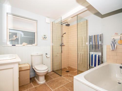 a bathroom with a toilet and a shower and a sink at Haven View in Neyland