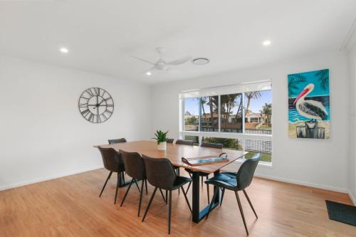 a dining room with a table and chairs at Lake House On Magellan 58 Ramsay Crescent in Golden Beach