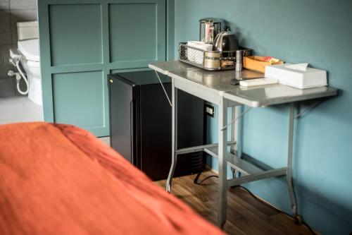 Hsin-yingにある未艾公寓WeLove Apartmentのテーブルと黒い冷蔵庫が備わる客室です。